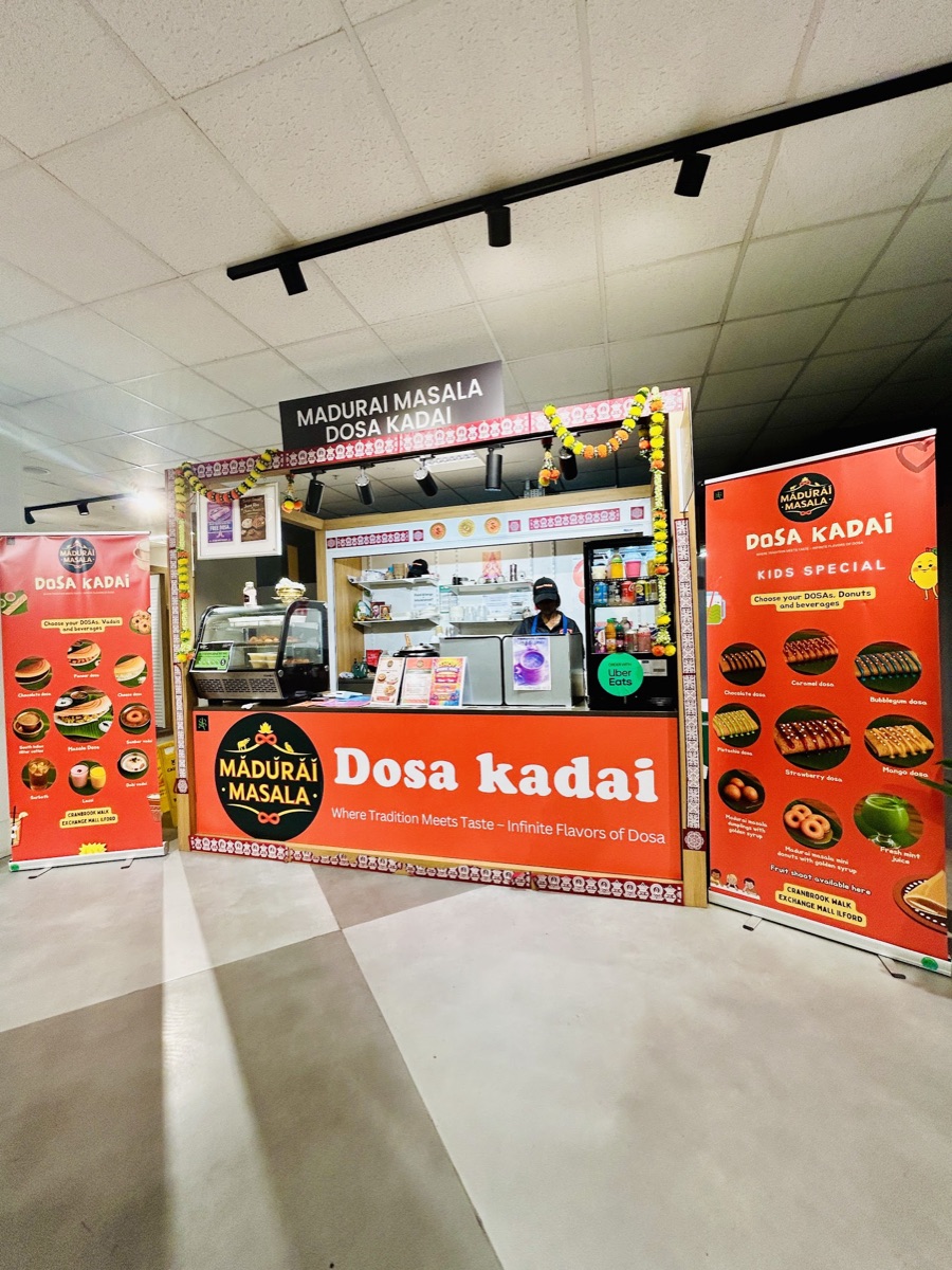 The Madurai Masala Dosa Kadai counter with the menu banners for dosas, vadai and beverages